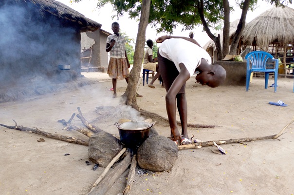 Jenifer Cana P6 Pupil of Ariwa Primary school in Ariwa village Rhinocamp Refugee settlement cooking beans using firewood She sales food ration ot By Firewood Photo By Robert Ariaka