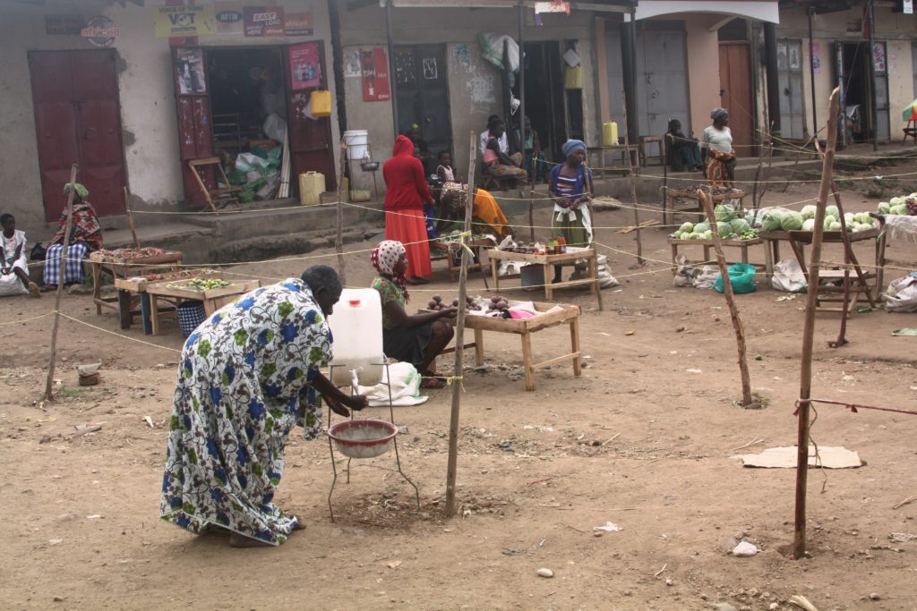 An elderly woman washes hands at Kazingo trading centre in Bukuuku sub county Kabarole district Uganda. Photo by Felix Basiime