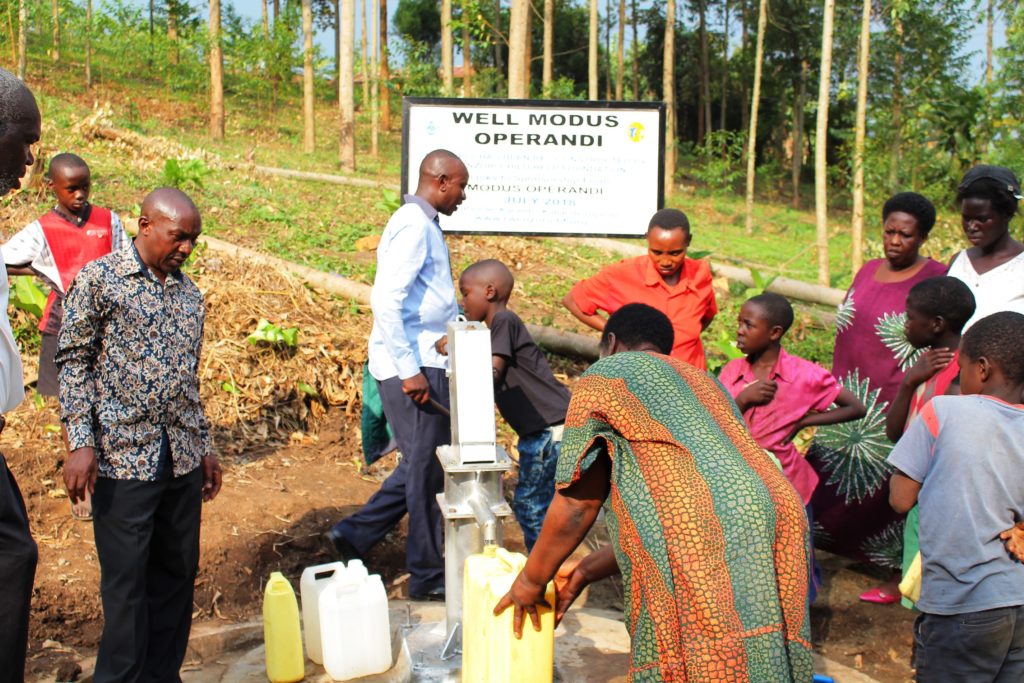 Residents of Kabende village in Kabarole district crowd at a water source to fetch water. Photo by ALEX ASHABA