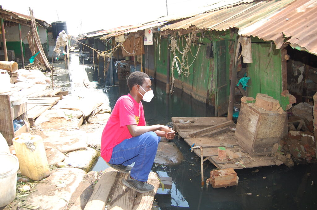 Copy of Noah Omuya looking at the flooded shop that belonged to Sarah Kaine before it was taken over by the water. 1