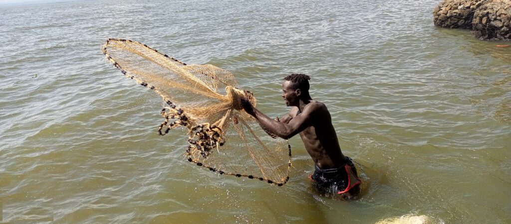 a man casting net on L. Victoria 2