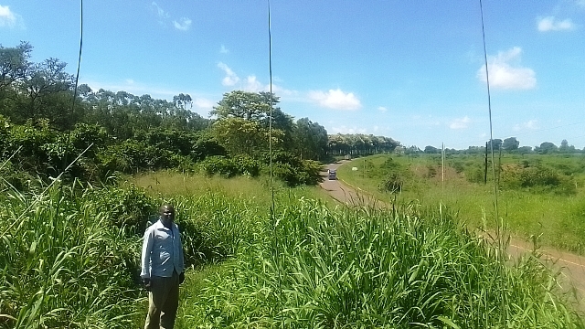 Otyeno stands behind the electric wire fence in Murcishion Falls National Park