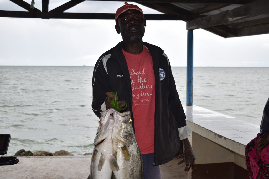 A fisherman holding nile perch after a fishing expedition