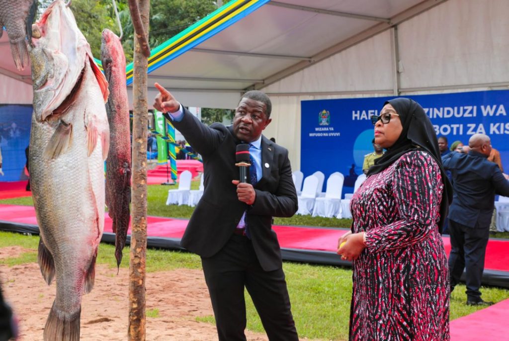 Tanzanian President Samia Suluhu Hassan listens intently as Minister of Livestock and Fisheries Abdallah Ulega details the diverse fish species in Lake Victoria