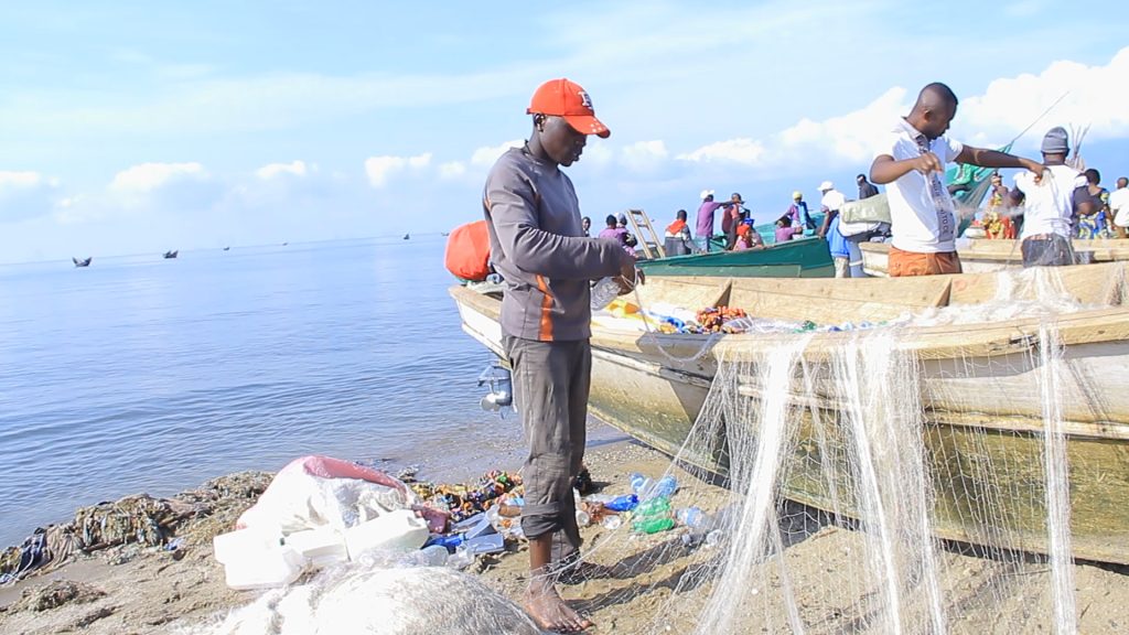 Fishermen prepare their fishing nets on the shores of Lake Edward