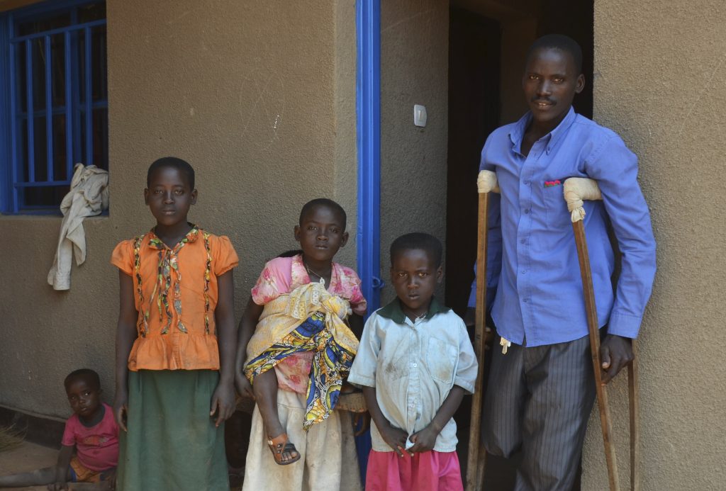 14 Hippo attack victim Antoine Mukeshimana poses for a photo with his children at his new house that he was given after relocating him from Sharita Island