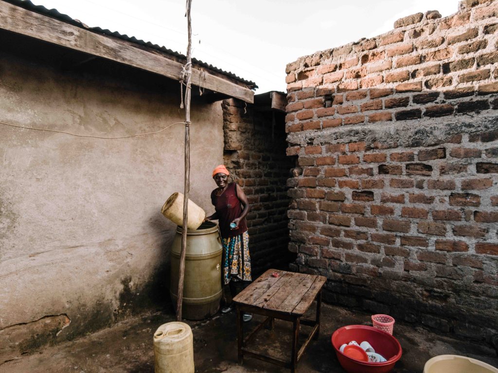 Mary akinyi pouring water outside