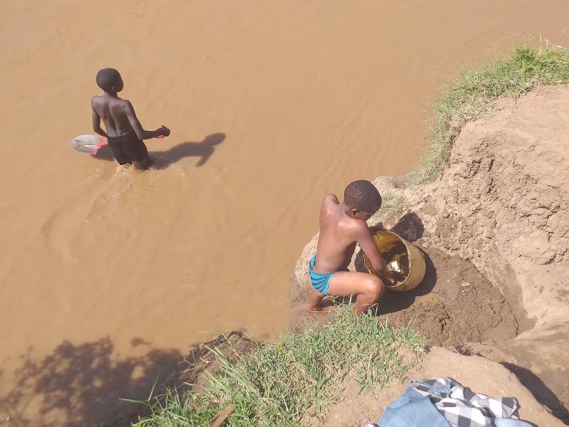 chidlren sandmining in river kibos