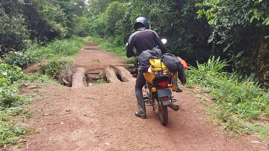 A motorbike approaches a dilapidated bridge on the way to Boteka 1 2